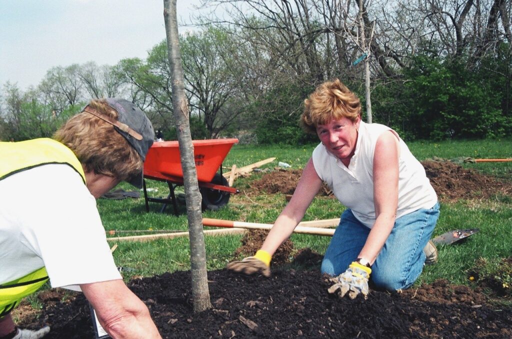 Barbara kneeling next to tree