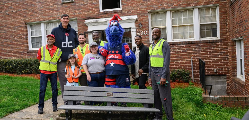 The Wizards and Casey Trees teams pose near a new bench dedicated to Benjamin Banneker