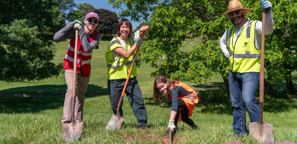 A team of volunteers pause digging to pose for a photo with their shovels at the Armed Forces Retirement Home
