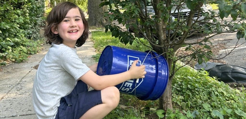 Elliot in June watering a young street tree