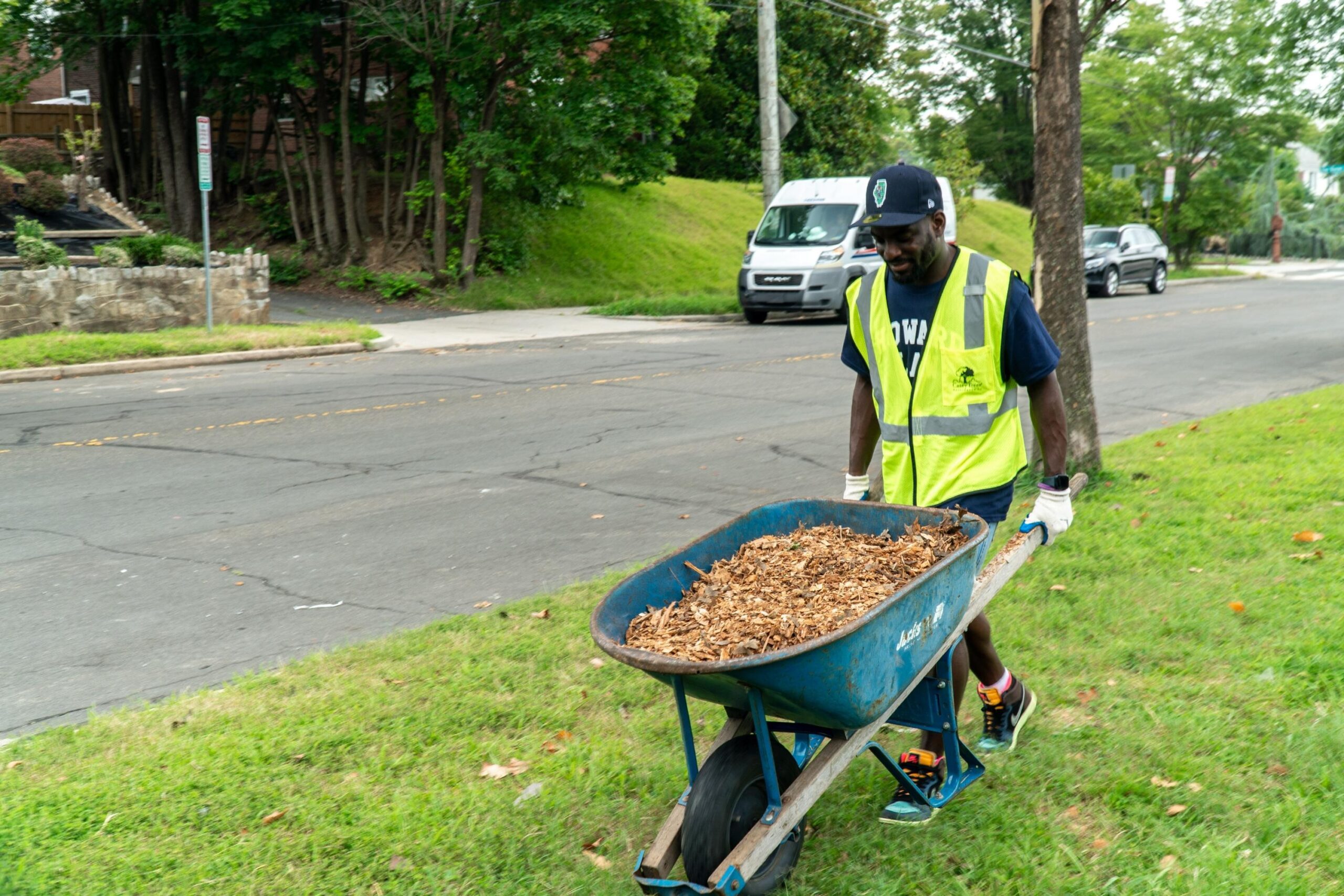 An incoming Howard University Law student pushes a wheelbarrow full of mulch.