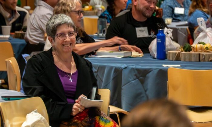 An audience member in a crowd smiles at the camera.