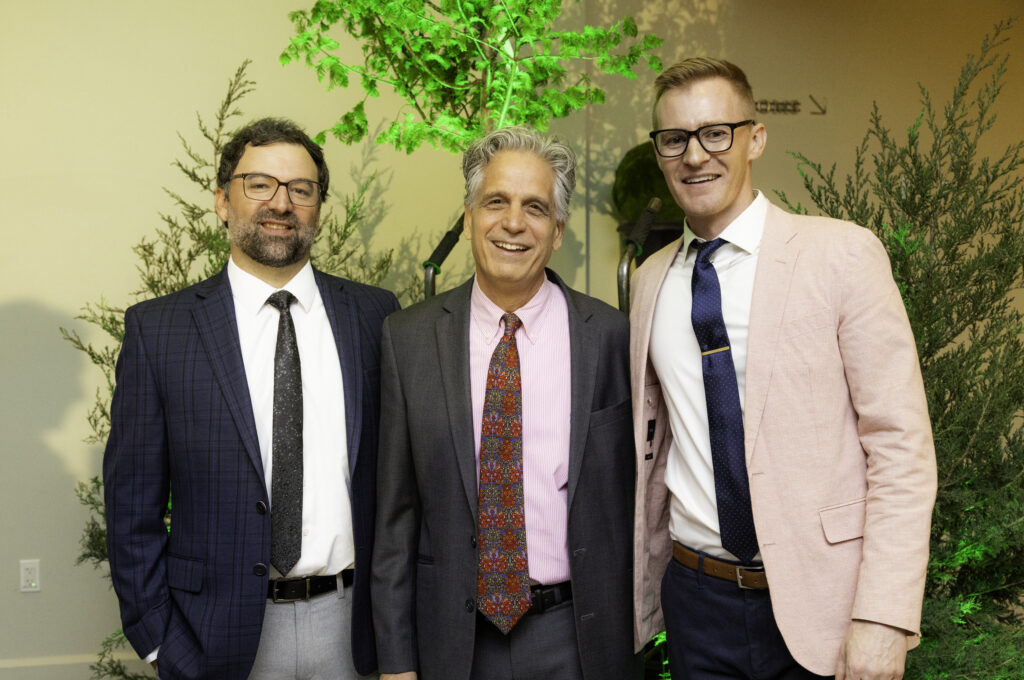 A group of 3 men posing for the camera