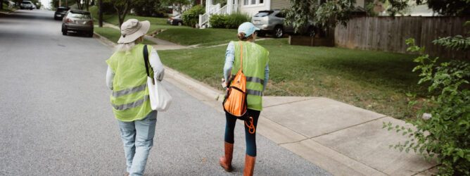 Two volunteers for CCAN walk on a road as they canvass.