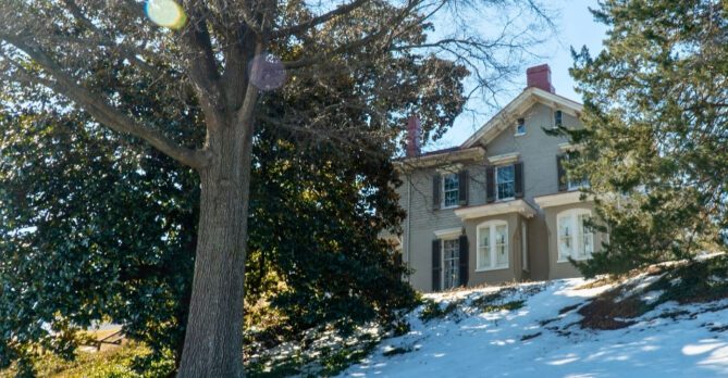 Frederick Douglass' home at Cedar Hill; a house on a hill surrounded by large trees.