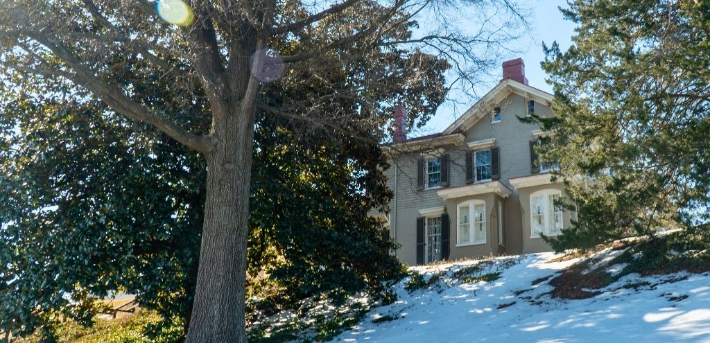 Frederick Douglass' home at Cedar Hill; a house on a hill surrounded by large trees.
