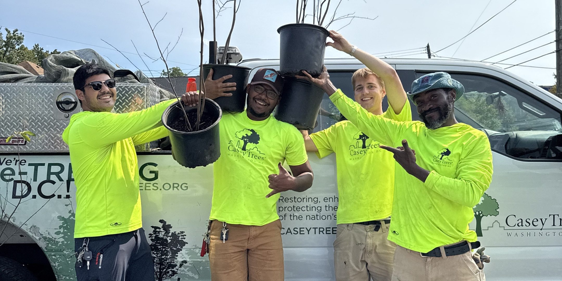 Casey Trees employees pose with giveaway trees.
