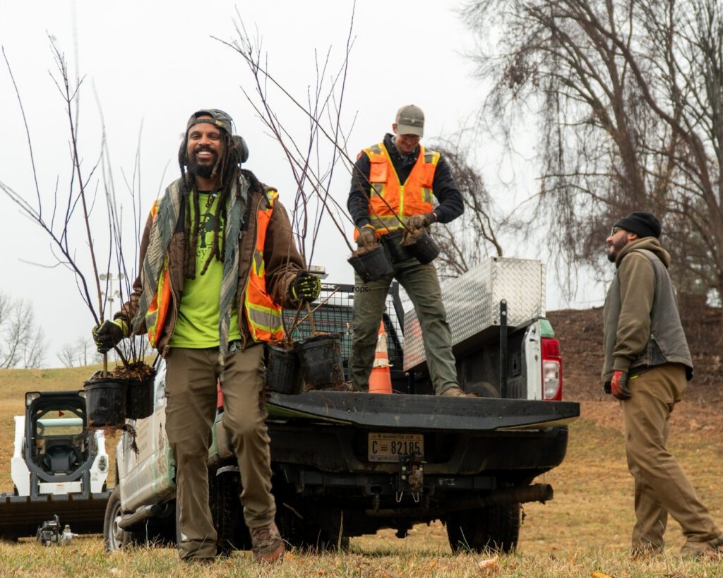 Casey Trees staff smile as they unload small trees from a Casey Trees truck.