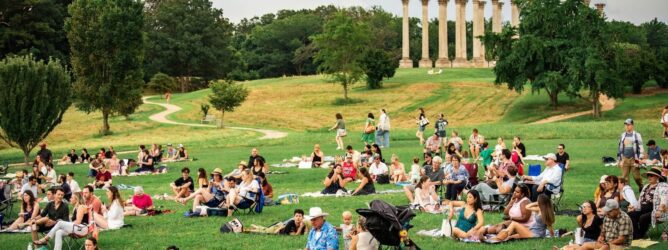 People sit in the meadow at the National Arboretum.