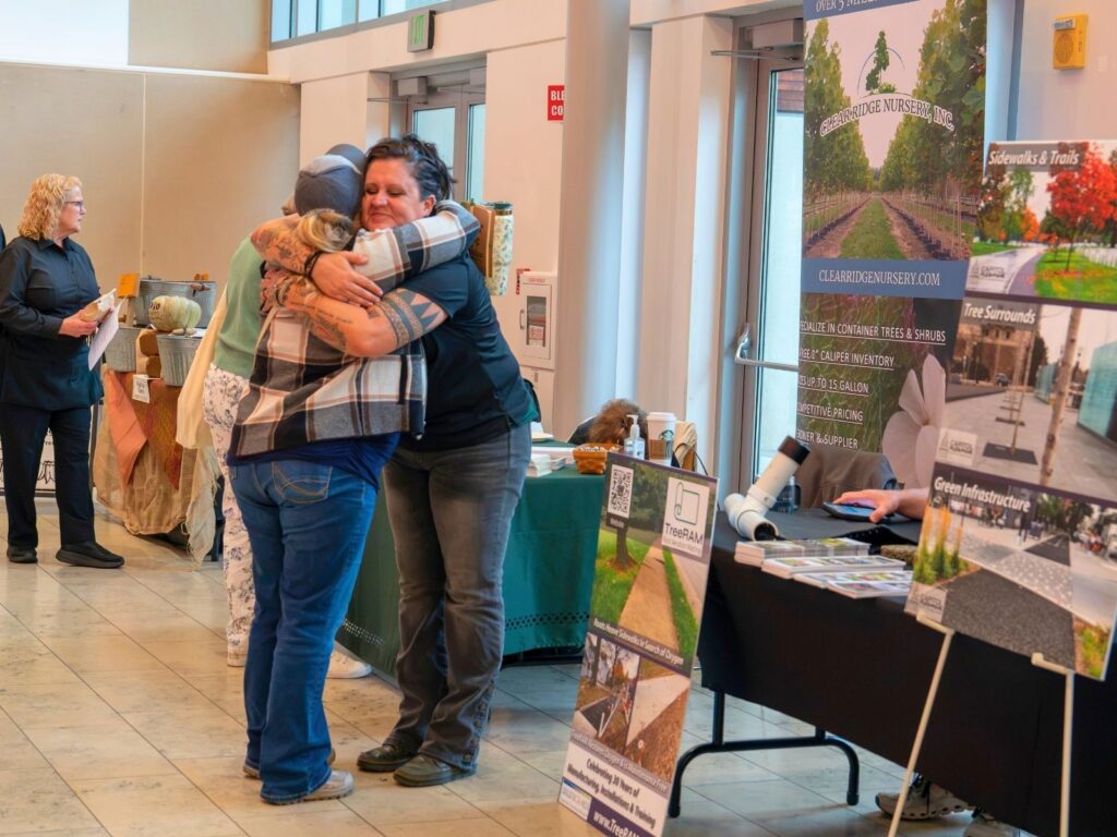 Two attendees hug at the Urban Tree Summit.
