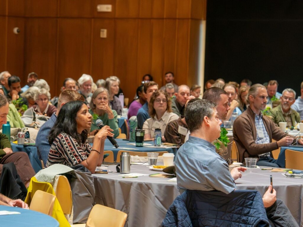 Speaker Priya Cook asks a question to speaker Tom Hill at the Urban Tree Summit.